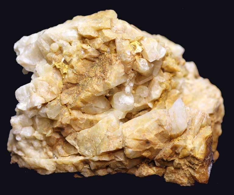 Colour image of yellow rock with multiple jagged edges and round chunks of white rock