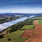 Photographie couleur d’un cours d’eau qui traverse des champs verdoyants