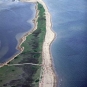 Photographie couleur d’une barre de sable couverte de végétation verdoyante, avec l’océan de part et d’autre